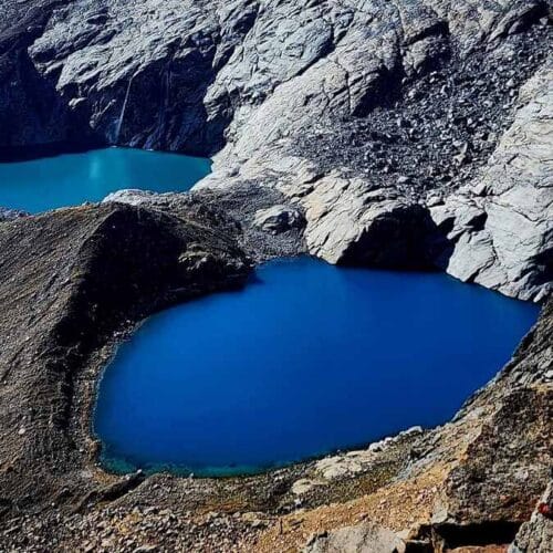 Hikers crossing remote Andean terrain during Four Lagoons trek