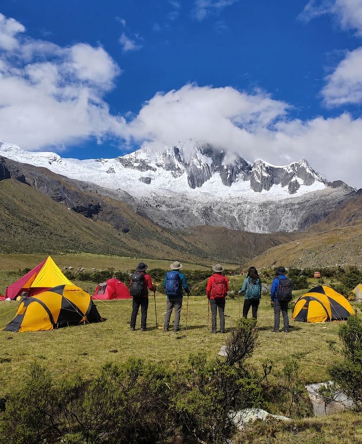 Trekkers hiking beneath snow-covered peaks in the Cordillera Blanca